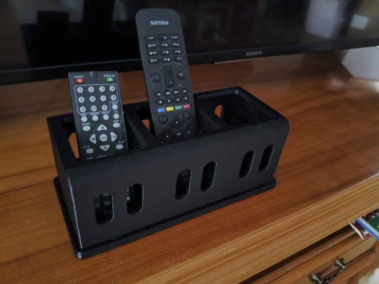 Czarny organizer na piloty z druku 3D na szafce RTV
